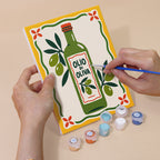 Hand holding an Italian Feast mini canvas while painting the details