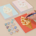 Painting one of the Jeweled Cones designs next to a stack of mini canvases