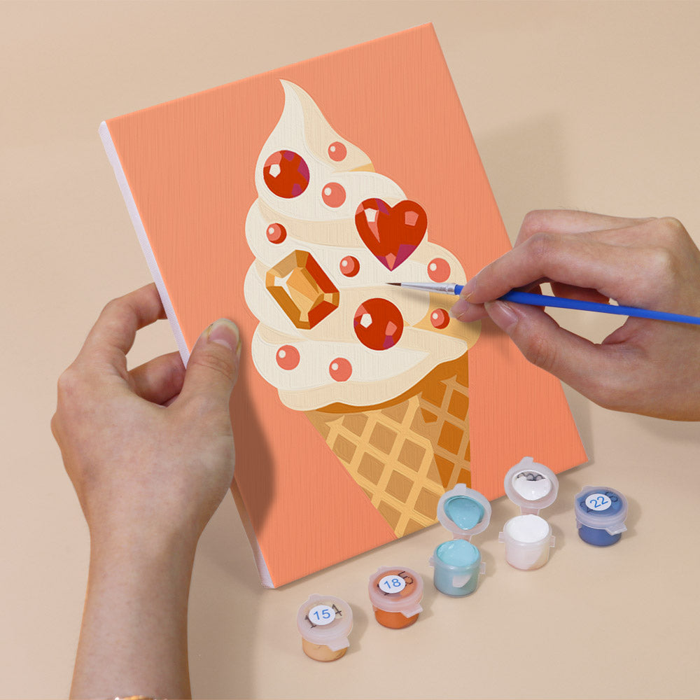 Hand holding a Jeweled Cones mini canvas while painting the details