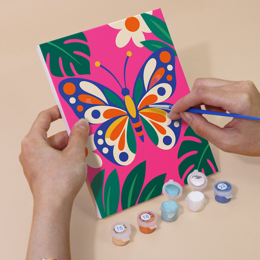 Hand holding a Jungle Bugs mini canvas while painting the details