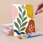 Painting a Jungle Collage mini canvas propped up beside numbered acrylic paints
