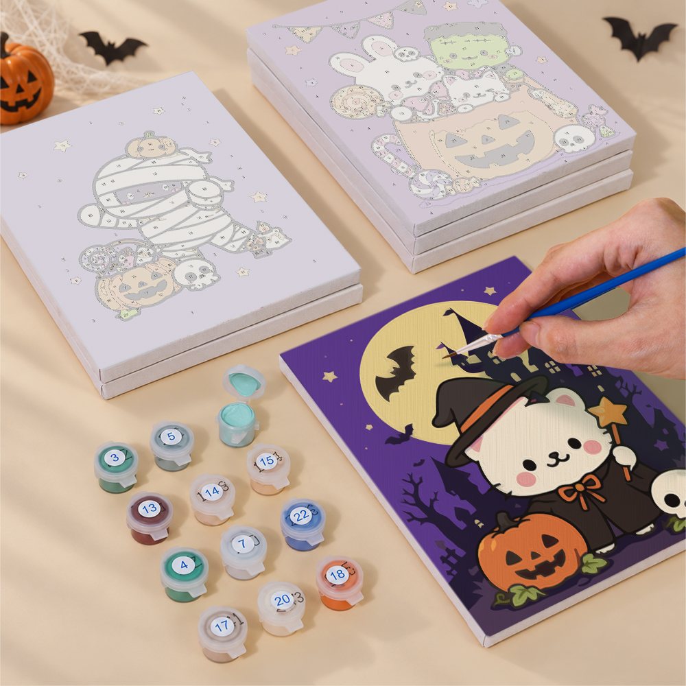 Painting one of the Kawaii Halloween designs next to a stack of mini canvases