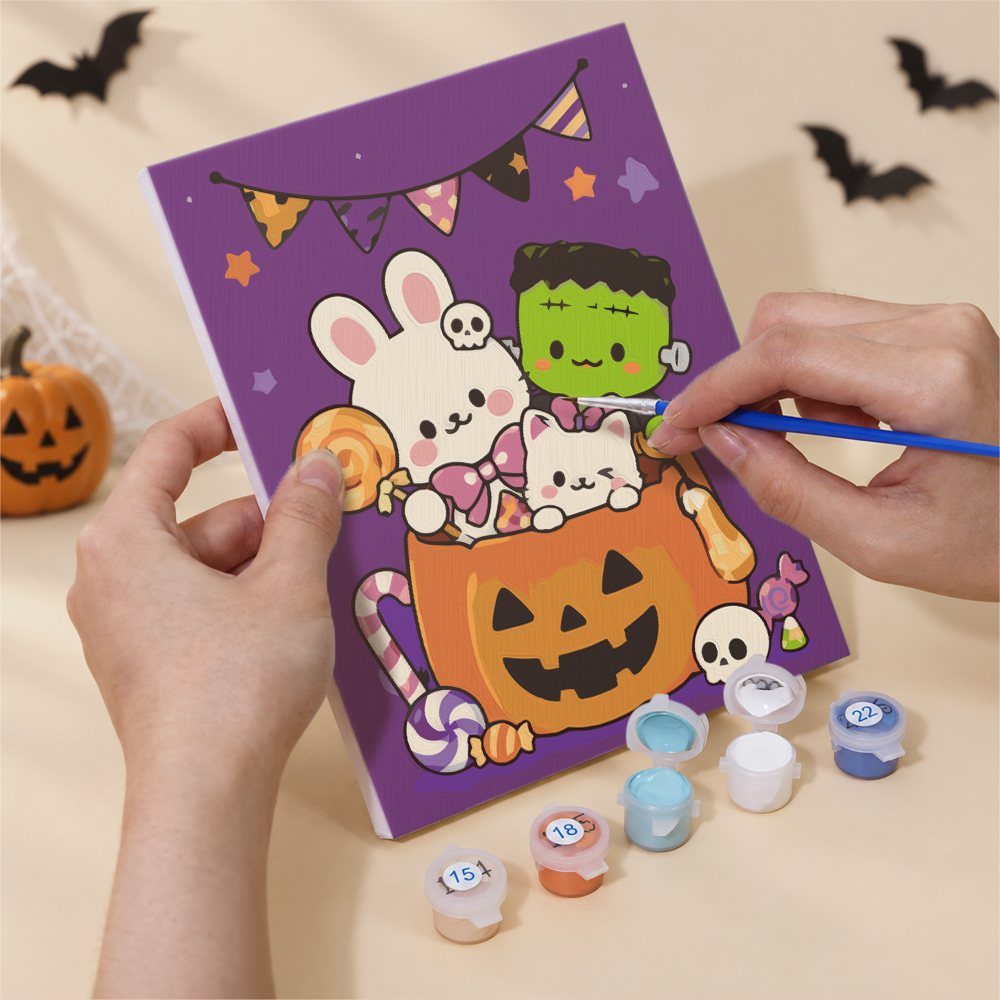 Hand holding a Kawaii Halloween mini canvas while painting the details