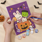 Hand holding a Kawaii Halloween mini canvas while painting the details
