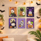 Six finished Kawaii Halloween mini paintings hung on a wall above a table