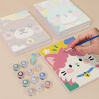 Painting one of the Kawaii Pals designs next to a stack of mini canvases
