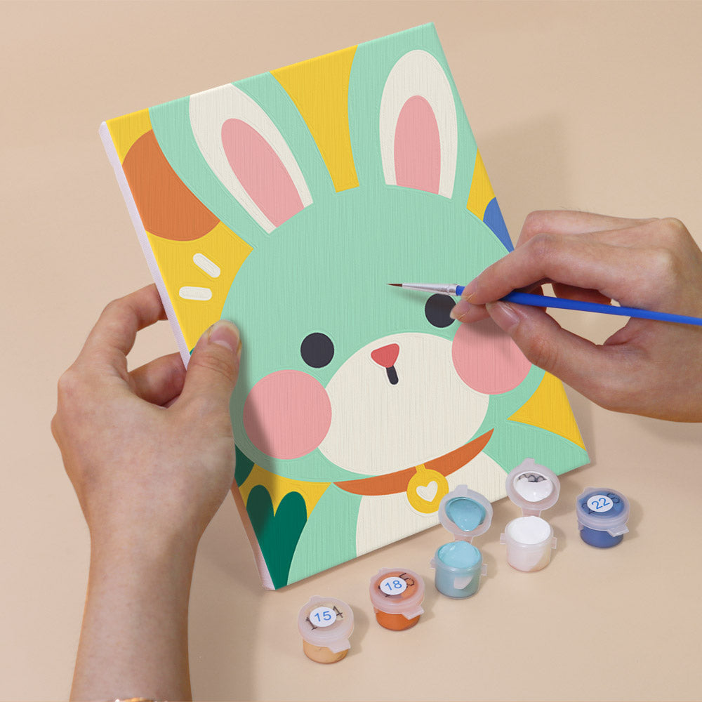 Hand holding a Kawaii Pals mini canvas while painting the details