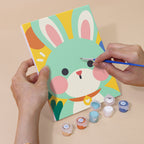 Hand holding a Kawaii Pals mini canvas while painting the details