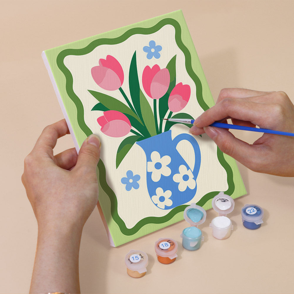 Hand holding a Kitchen Charm mini canvas while painting the details