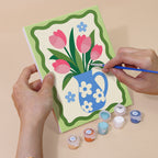 Hand holding a Kitchen Charm mini canvas while painting the details