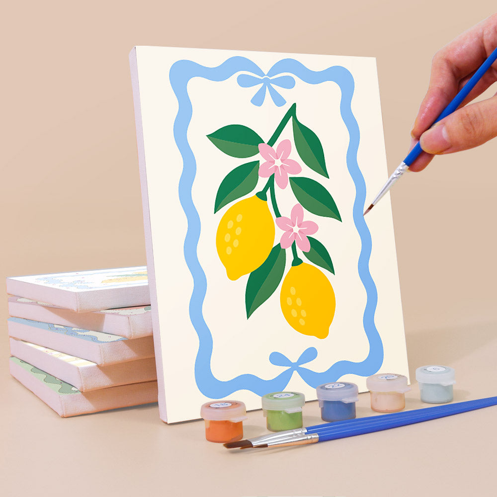 Painting a Kitchen Charm mini canvas propped up beside numbered acrylic paints