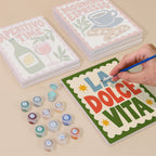 Painting one of the La Dolce Vita designs next to a stack of mini canvases