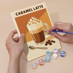 Hand holding a Latte Menu mini canvas while painting the details