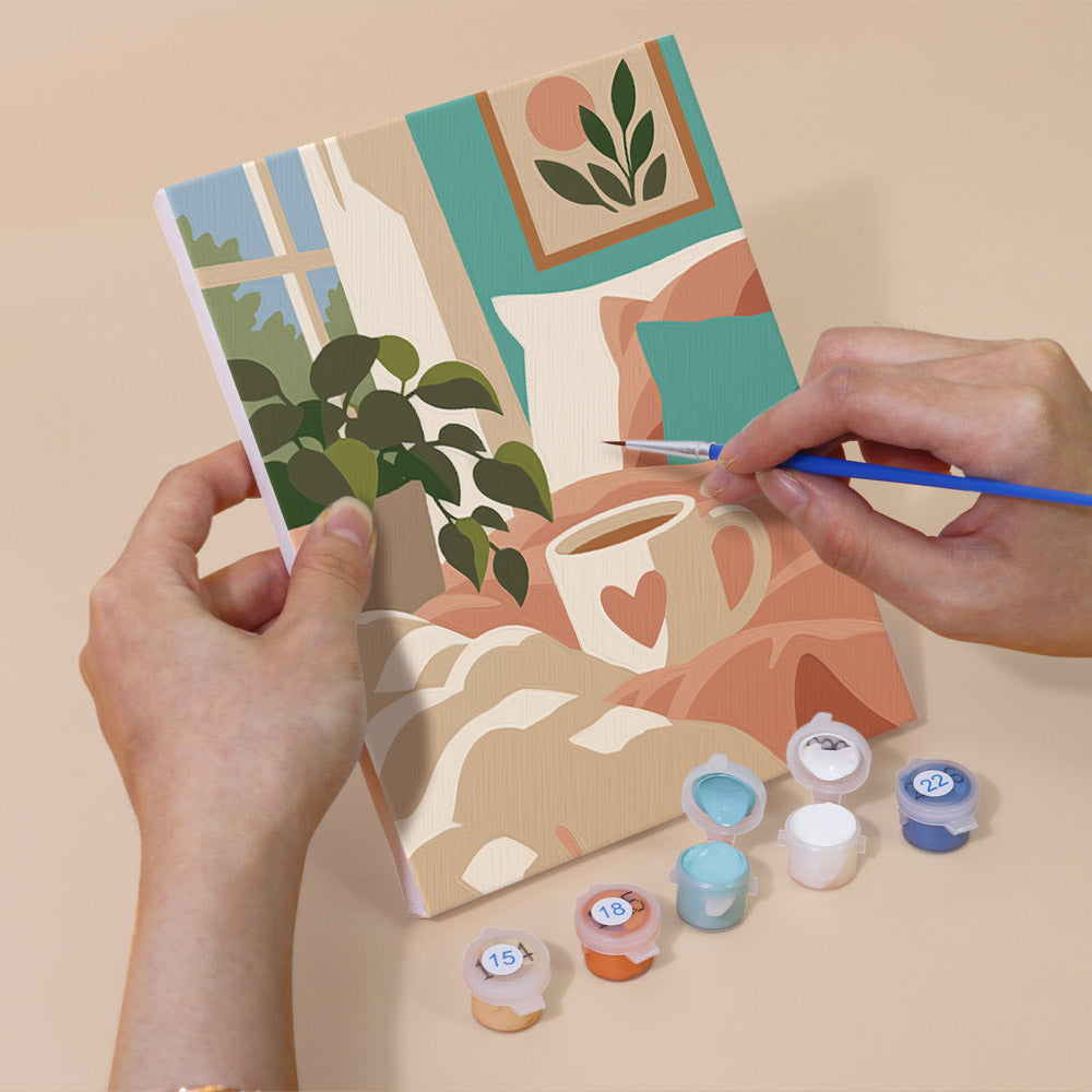 Hand holding a Lazy Sundays mini canvas while painting the details