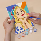 Hand holding a Lipstick & Attitude mini canvas while painting the details