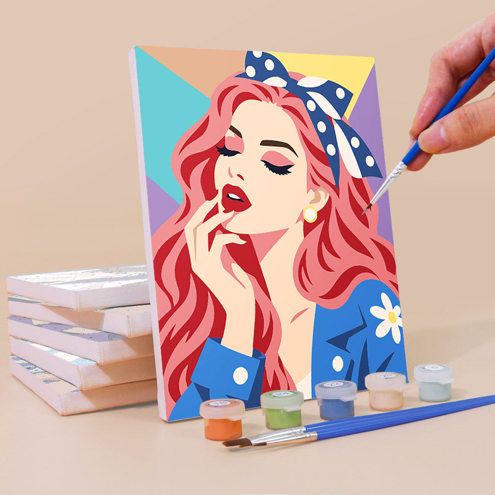 Painting a Lipstick & Attitude mini canvas propped up beside numbered acrylic paints