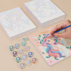 Painting one of the Little Angels designs next to a stack of mini canvases