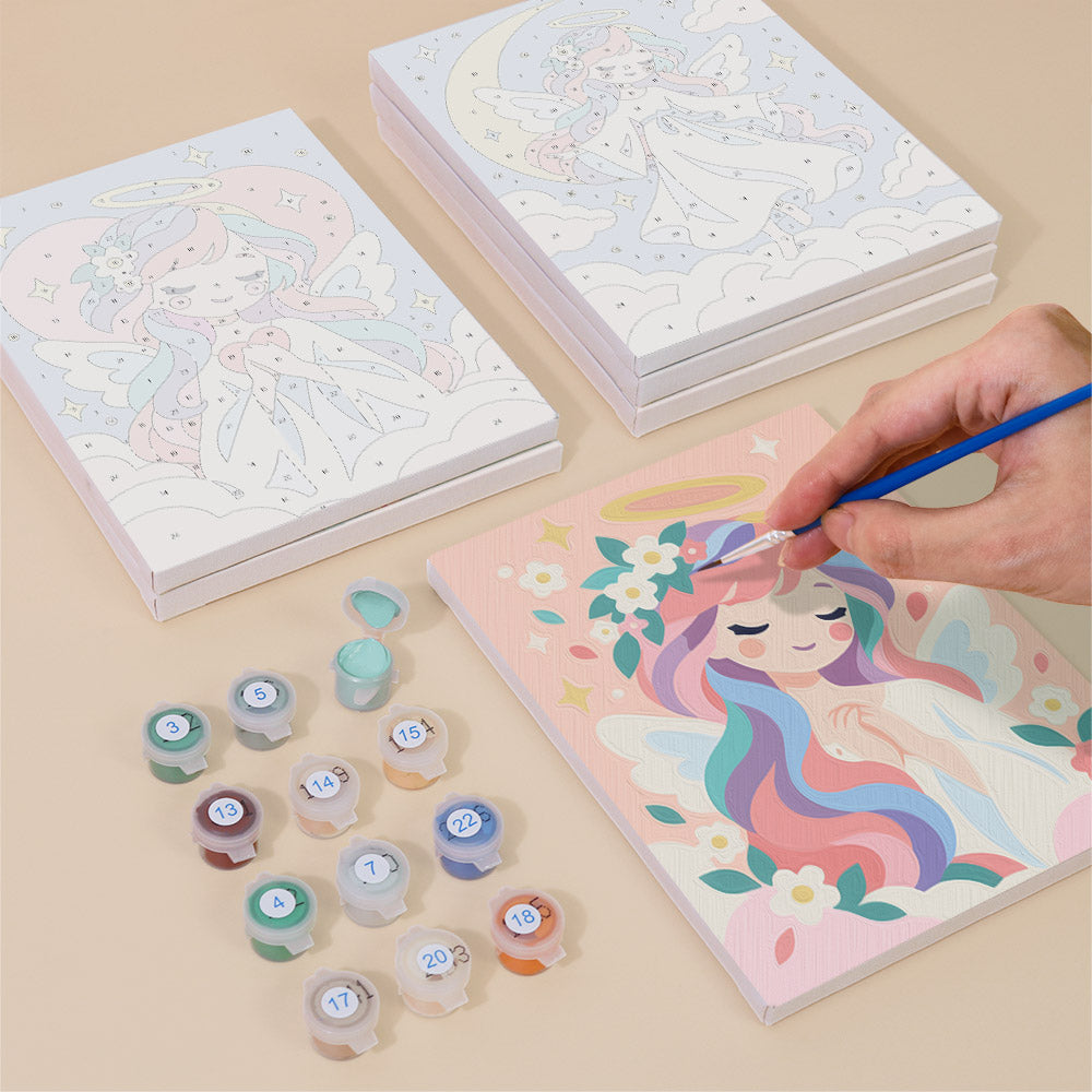 Painting one of the Little Angels designs next to a stack of mini canvases
