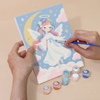 Hand holding a Little Angels mini canvas while painting the details