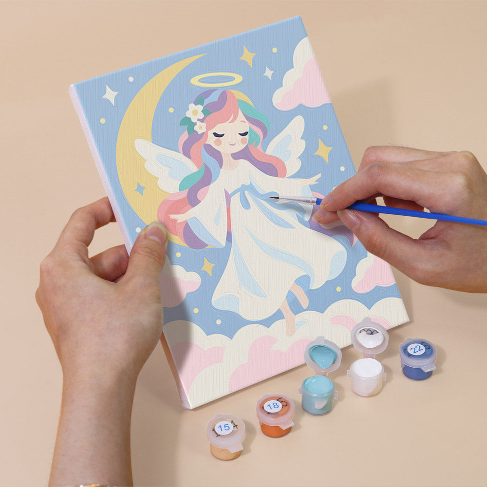 Hand holding a Little Angels mini canvas while painting the details