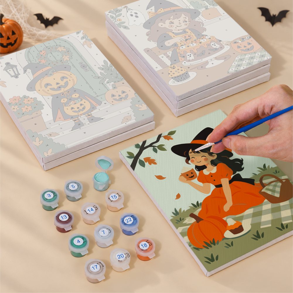 Painting one of the Little Autumn Witches designs next to a stack of mini canvases