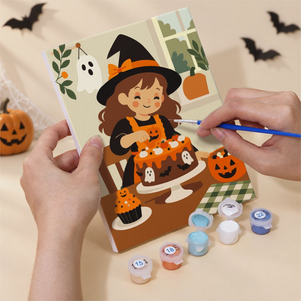 Hand holding a Little Autumn Witches mini canvas while painting the details