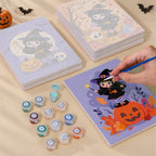 Painting one of the Little Witch Adventures designs next to a stack of mini canvases
