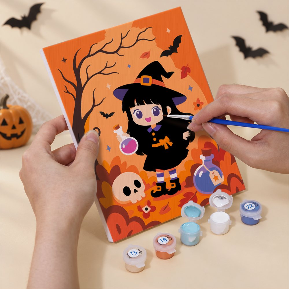 Hand holding a Little Witch Adventures mini canvas while painting the details