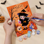 Hand holding a Little Witch Adventures mini canvas while painting the details