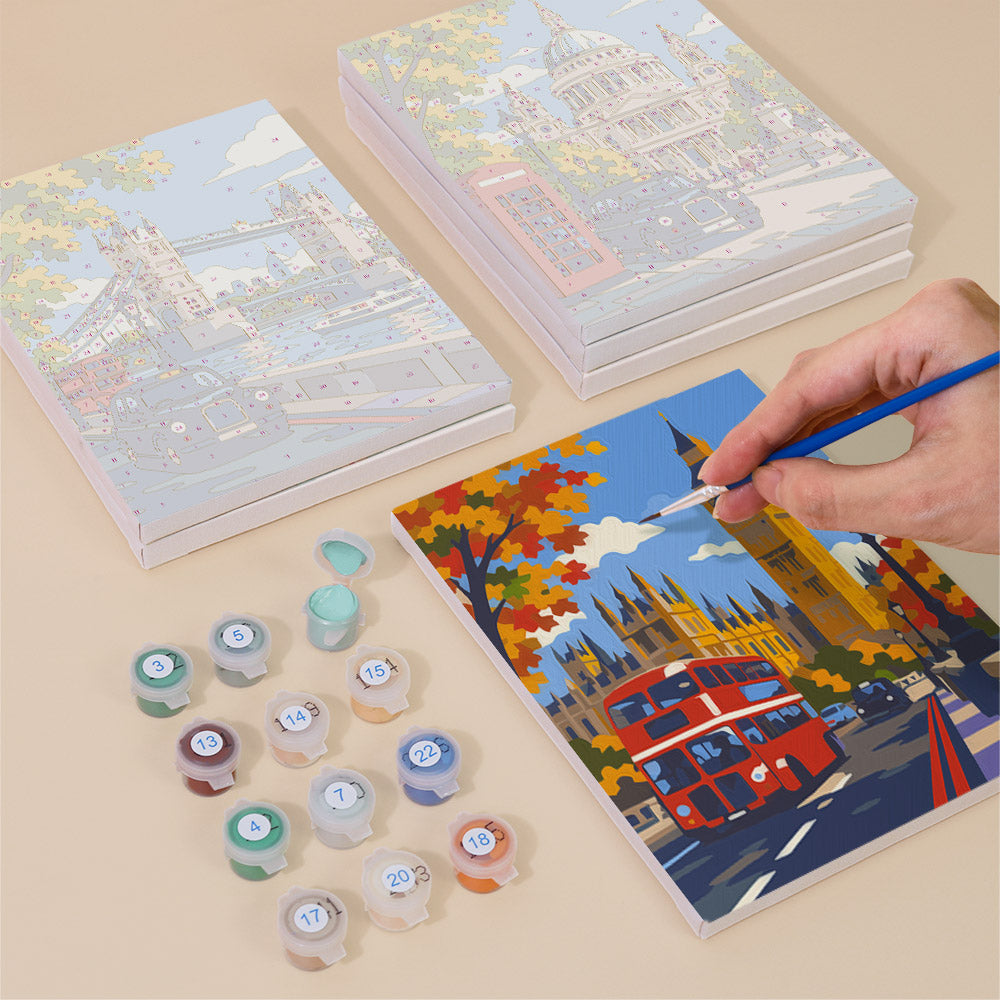 Painting one of the London Days designs next to a stack of mini canvases