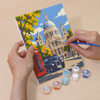 Hand holding a London Days mini canvas while painting the details
