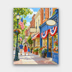 Main Street on the Fourth paint by numbers kit of a small-town main street with brick shops, American flags and red, white and blue bunting
