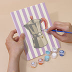 Hand holding a Market Stripes mini canvas while painting the details