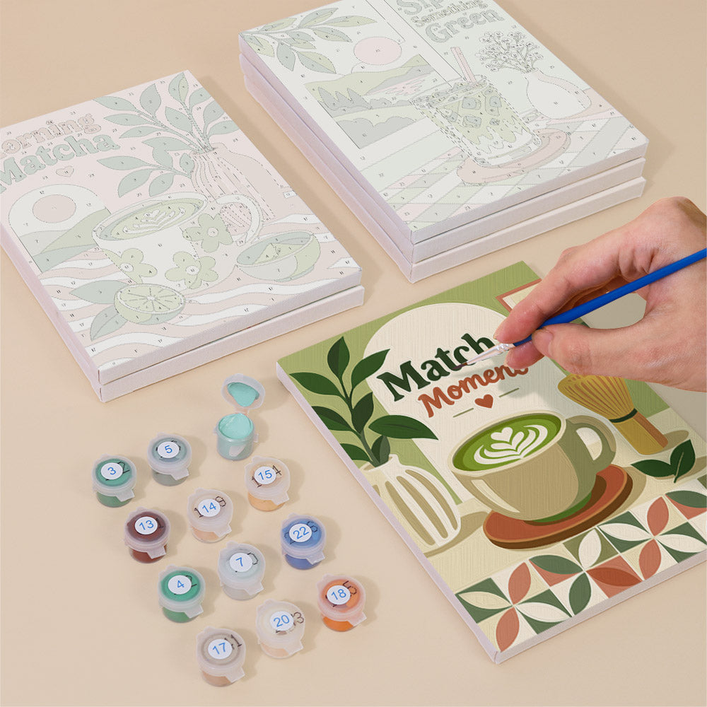Painting one of the Matcha Moments designs next to a stack of mini canvases