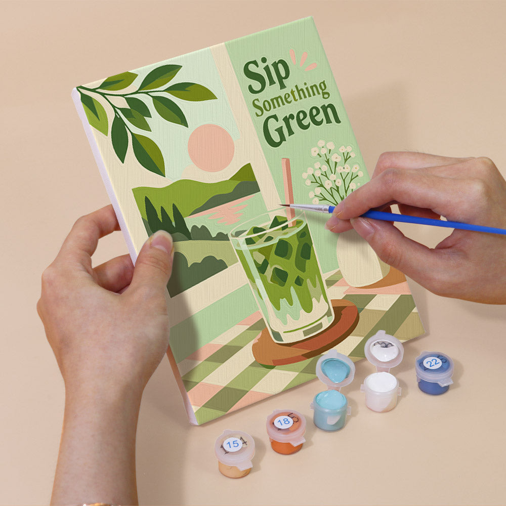 Hand holding a Matcha Moments mini canvas while painting the details