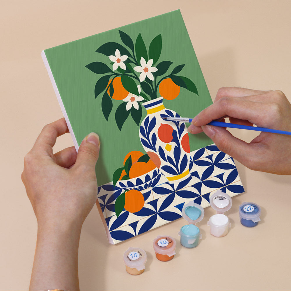 Hand holding a Mediterranean Summer mini canvas while painting the details