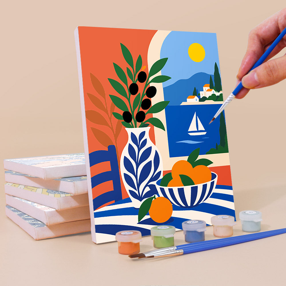 Painting a Mediterranean Summer mini canvas propped up beside numbered acrylic paints