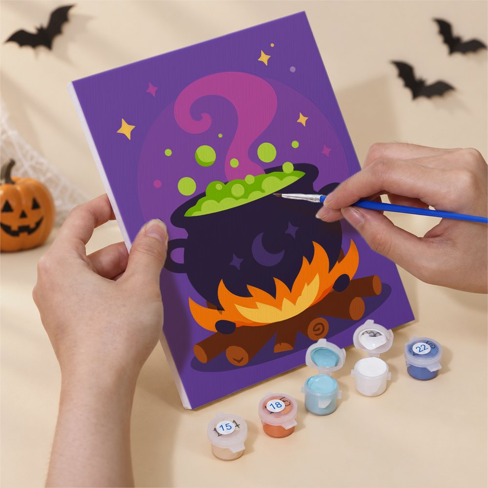 Hand holding a Midnight Friends mini canvas while painting the details