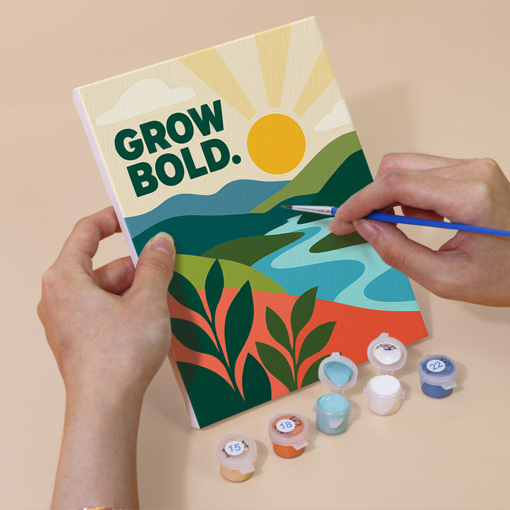 Hand holding a Mindful Mantras mini canvas while painting the details