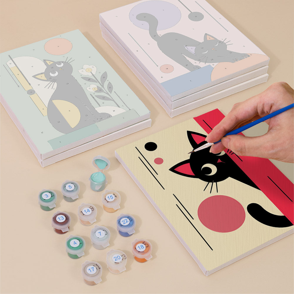 Painting one of the Mod Cats designs next to a stack of mini canvases