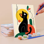 Painting a Mod Cats mini canvas propped up beside numbered acrylic paints