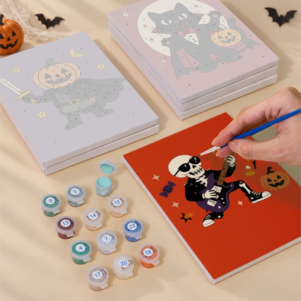Painting one of the Monster Mash designs next to a stack of mini canvases