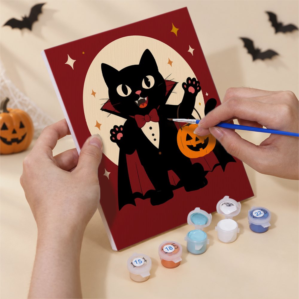 Hand holding a Monster Mash mini canvas while painting the details