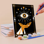 Painting a Moon Magic mini canvas propped up beside numbered acrylic paints
