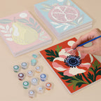 Painting one of the Moonlit Botanicals designs next to a stack of mini canvases