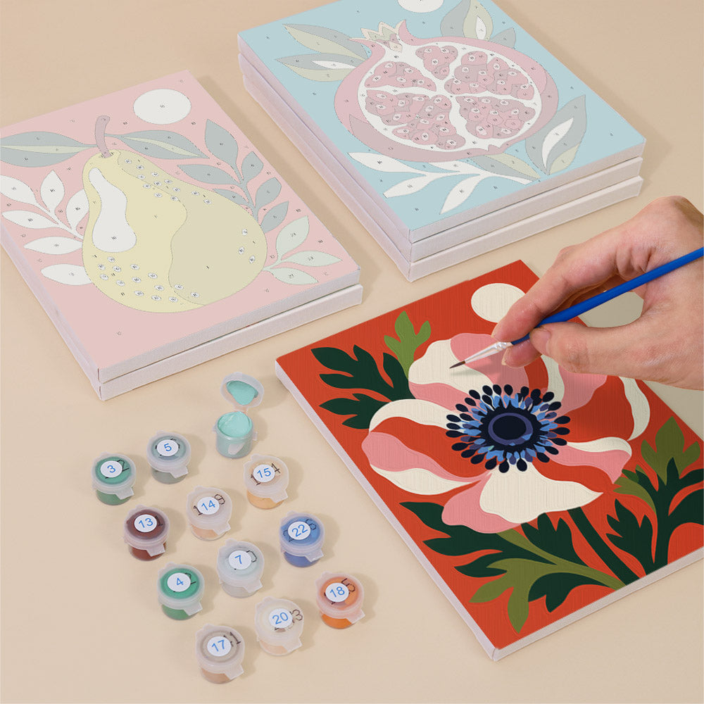 Painting one of the Moonlit Botanicals designs next to a stack of mini canvases