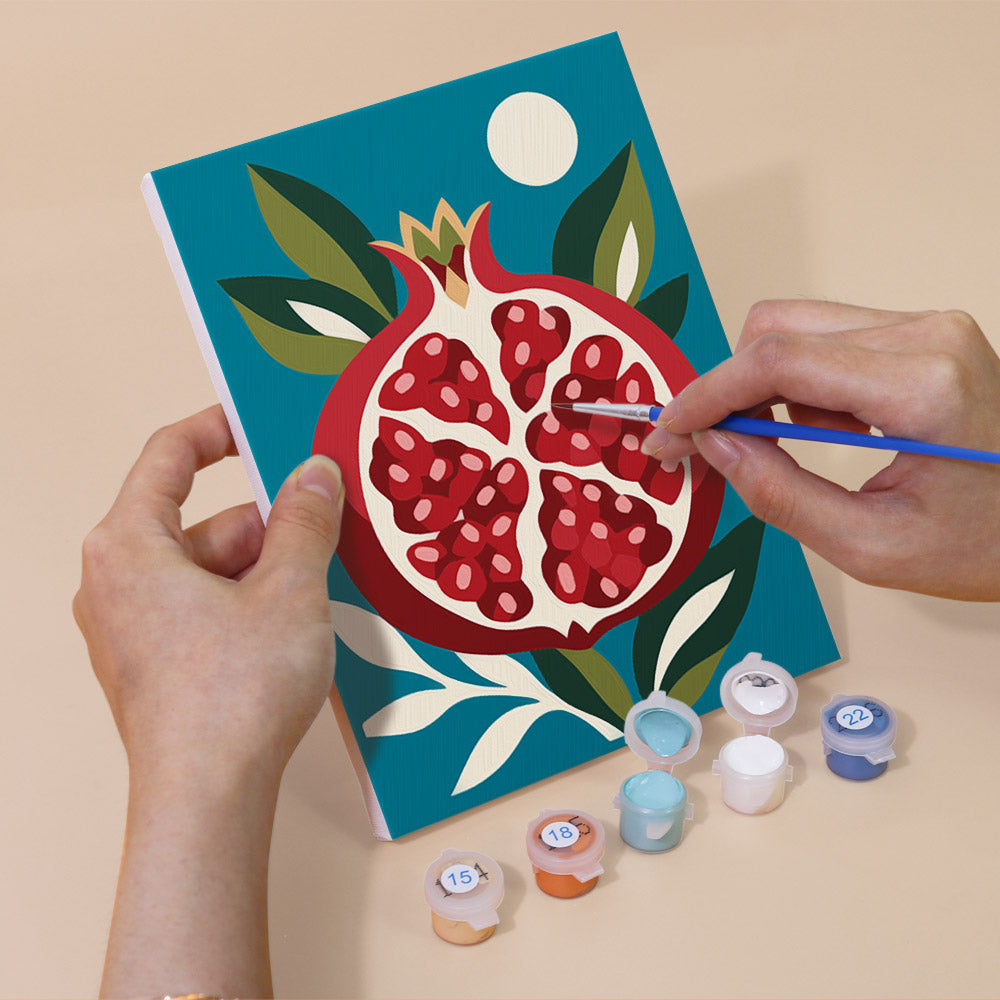 Hand holding a Moonlit Botanicals mini canvas while painting the details