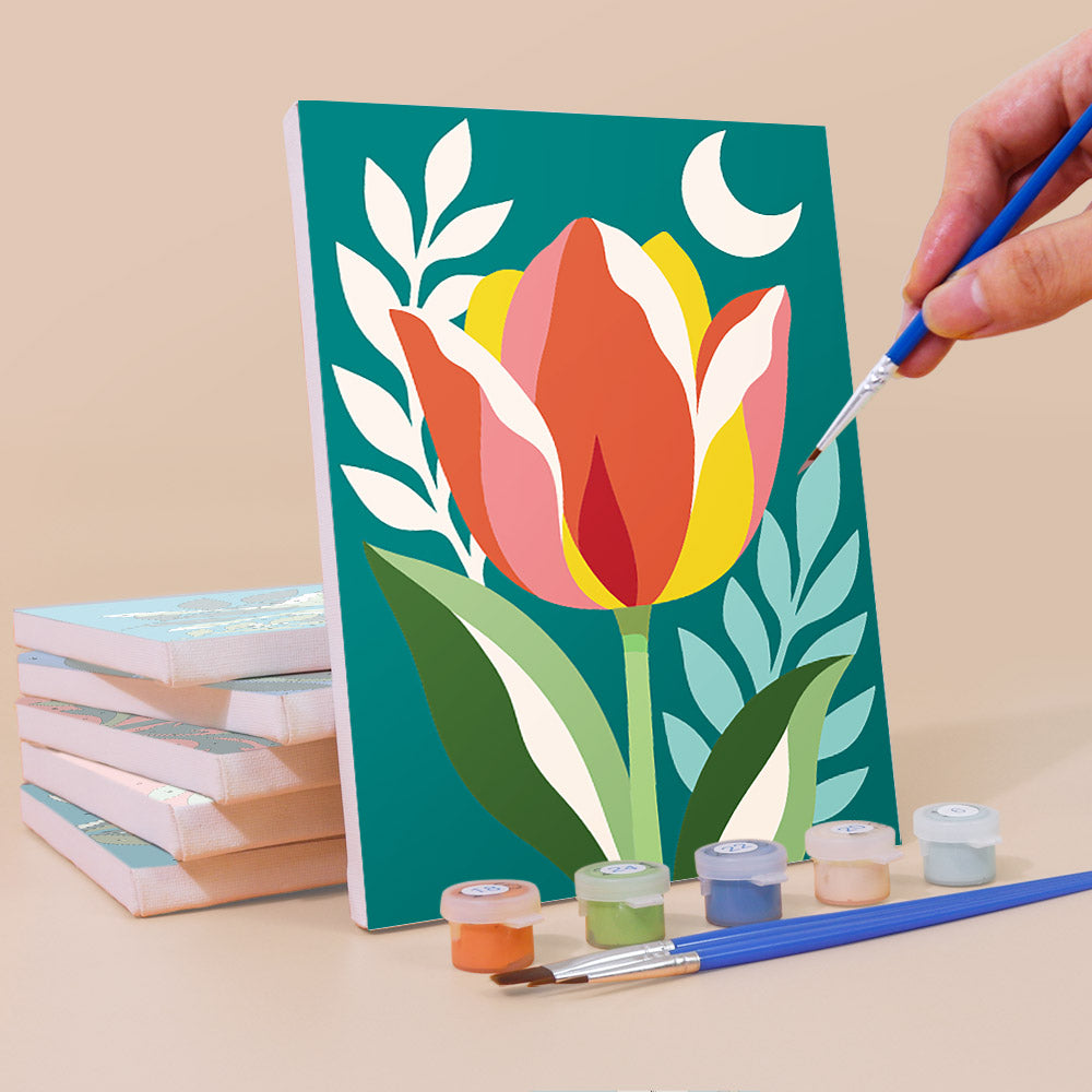 Painting a Moonlit Botanicals mini canvas propped up beside numbered acrylic paints