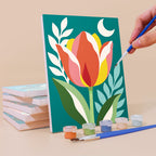 Painting a Moonlit Botanicals mini canvas propped up beside numbered acrylic paints