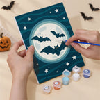 Hand holding a Moonlit Halloween mini canvas while painting the details